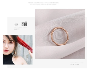 Detail view of rose gold bamboo design ring on soft grey fabric with a magazine layout style