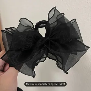 Detail of a 17cm large black mesh bow hair claw clip featuring tiered organza texture