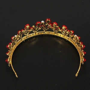 Golden bridal crown with red roses and white pearls on a minimalist black background