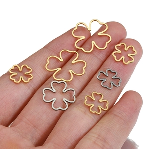 18k gold and silver stainless steel hollow clover pendants in various sizes on a hand