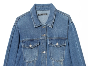 Close-up of blue denim jacket collar with metal buttons and stitched chest pockets