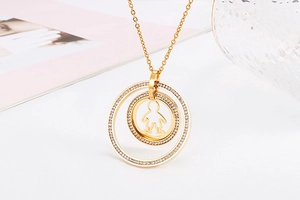 Detail of gold-plated concentric circle necklace with crystals and boy silhouette