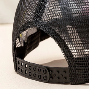 Close-up of adjustable snapback closure and breathable black mesh on the trucker hat