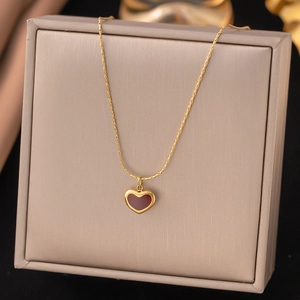 Detailansicht einer goldenen Herzanhänger-Halskette mit dunklem Inlay in einer Schmuckbox