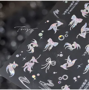 Macro detail of holographic laser nail stickers featuring goldfish and butterfly designs