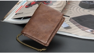 Brown leather men's wallet with metal chain and embossed brand logo on vintage magazine