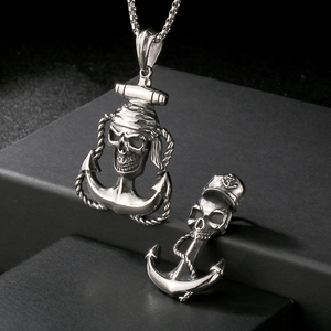 Nahaufnahme von Edelstahl-Totenkopf- und Ankeranhängern im Punk-Piratenstil