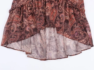 Detailed view of bohemian paisley chiffon dress hem with layered ruffle elements