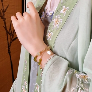 Détail du lot de bracelets style chinois avec motif bambou et pendentif fleur sur le poignet