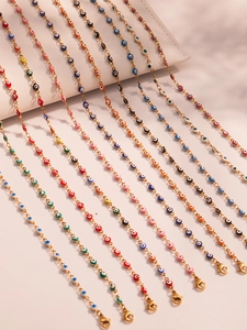 Detailopname van veelkleurige emaille boze oog kralen op een gouden roestvrijstalen ketting