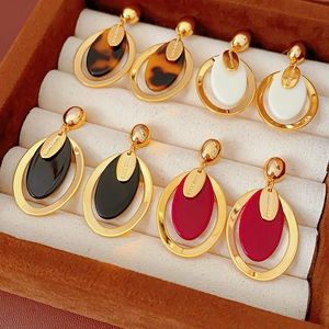 Detail of four oval resin earrings in various colors on a luxury jewelry box padding