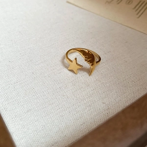 Macro detail of 18k gold plated stainless steel open ring with crescent moon and star