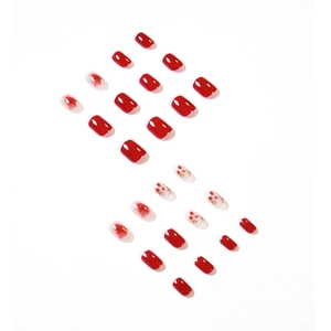 Faux ongles rouge aubépine avec motifs floraux et dégradés sur un fond blanc épuré
