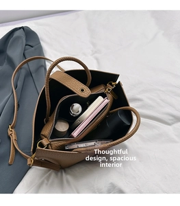 Internal view of the caramel lychee leather bucket bag with multiple compartments and makeup