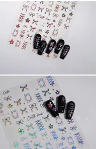 Macro shot of laser butterfly and floral nail art stickers on black base nails