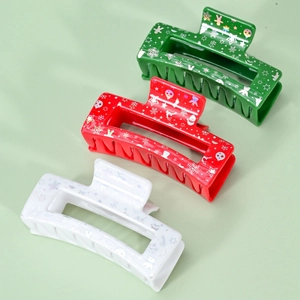 Detailed view of three acrylic Christmas hair claws with festive reindeer and snowflake prints