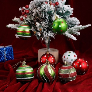 Detail of glittery red, green and white Christmas balls with patterns on tree branch