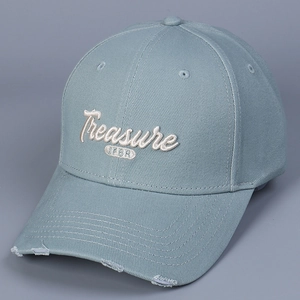 Detailed macro view of white 3D letter embroidery and vintage distressed cap brim