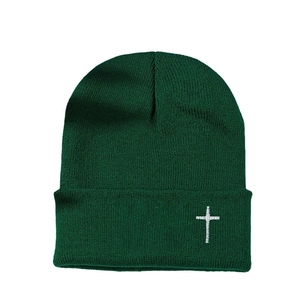 Bonnet en maille vert foncé avec broderie croix blanche au style d'hiver sobre