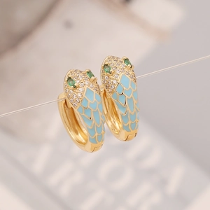 Macro detail of snake head earring with sky blue enamel and green gemstone eyes