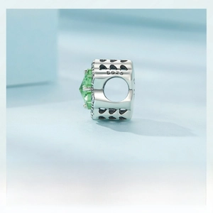 Macro shot of S925 sterling silver four-leaf clover charm with green faceted gemstone