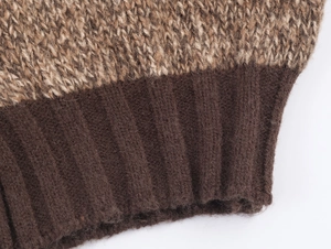 Detail of ribbed dark brown cuffs and light brown knit texture on a cozy cardigan