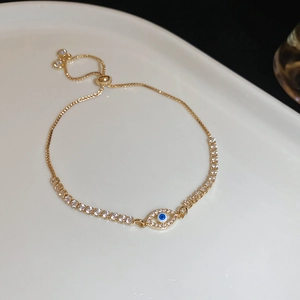 Macro shot of gold evil eye bracelet with blue zircons and adjustable pull-cord chain