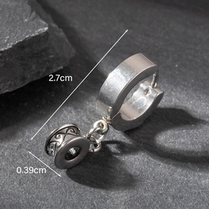 Macro shot of silver stainless steel earring showing engraved patterns and dimensions