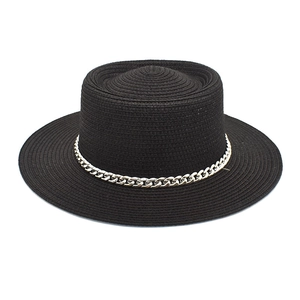 Detail of black straw boater hat featuring a woven texture and silver curb chain decor