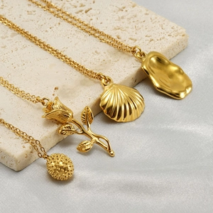Golden rose and shell pendant necklace set on elegant beige stone and white silk