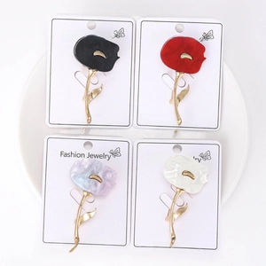 Detailed set of four alloy flower brooches in black red purple and white on cards