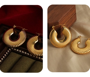 Detailed macro view of 18k gold hoop earrings with vertical ribbed texture and pins
