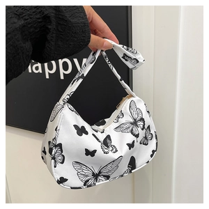 Detail of trendy shoulder bag with black butterfly print on white PU leather material