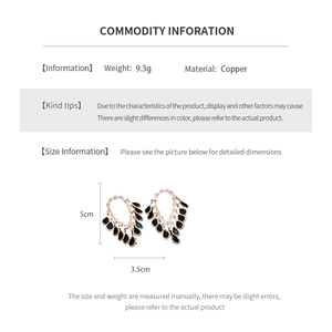Detail view of gold drop earrings with black stones showing dimensions 5cm by 3.5cm