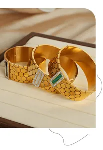 Macro shot of gold cuff bracelets with honeycomb texture and malachite stone inlays