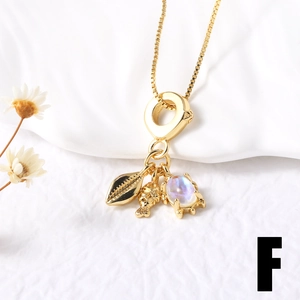 Detail of gold layered necklace with shell, fish pendants and iridescent gemstone