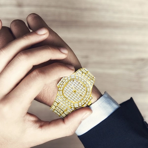 Close-up of golden diamond-set watch crown being adjusted on a luxury men's timepiece