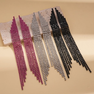Sparkling long tassel rhinestone earrings in pink, silver, and black on a stone tray