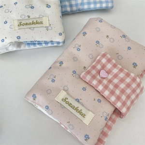 Close-up of floral fabric notebook covers with heart buttons and Sozakka embroidery