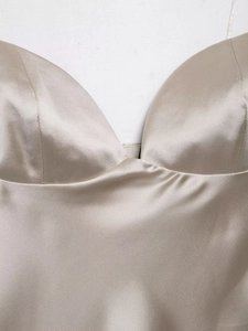 Close-up of champagne satin camisole showing sweetheart neckline and fine stitching details