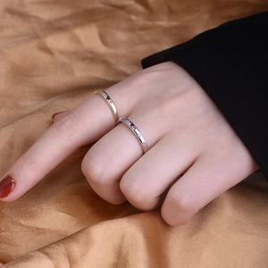Close-up of gold and silver S925 rings with colorful zircons on golden silk fabric