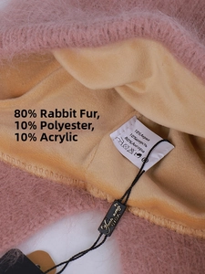 Details einer rosa Angora-Kaninchenfellmütze mit warmem Fleecefutter und Stoffetikett