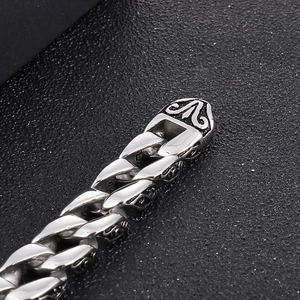 Macro detail of silver stainless steel Cuban chain bracelet with vintage floral engravings