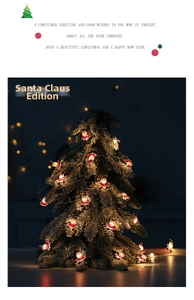 Detail of Santa Claus LED string lights draped over pine branches with festive bokeh