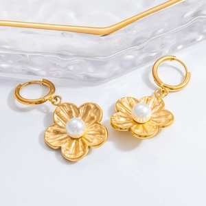 Elegant gold flower earrings with white pearl center in a minimalist fashion design