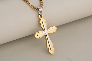 Detailed view of dual-tone gold and silver stainless steel religious cross pendant with chain