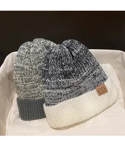 Close-up of knit winter beanies with thick fleece lining and faux leather patch detail