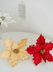 Detailed view of red and champagne artificial poinsettia flowers with gold glitter edges