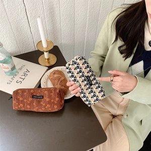 Handheld corduroy pencil case with vintage floral pattern and merciparis woven label