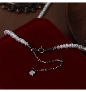 Macro shot of S925 silver clasp and heart pendant on freshwater pearl necklace